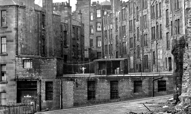 A view of old, weathered stone buildings with multiple windows and chimneys.